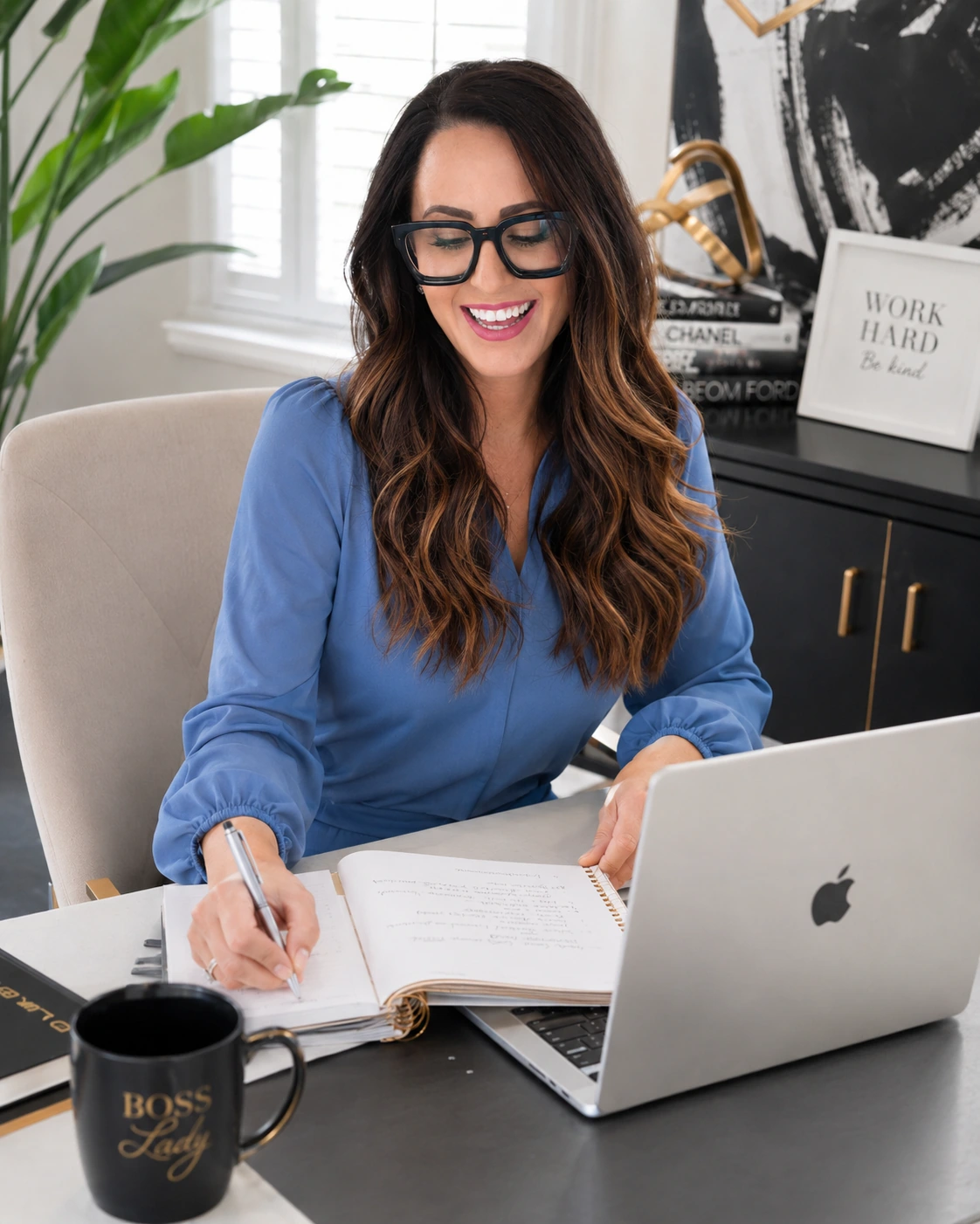 Portrait at a desk with a notebook and laptop