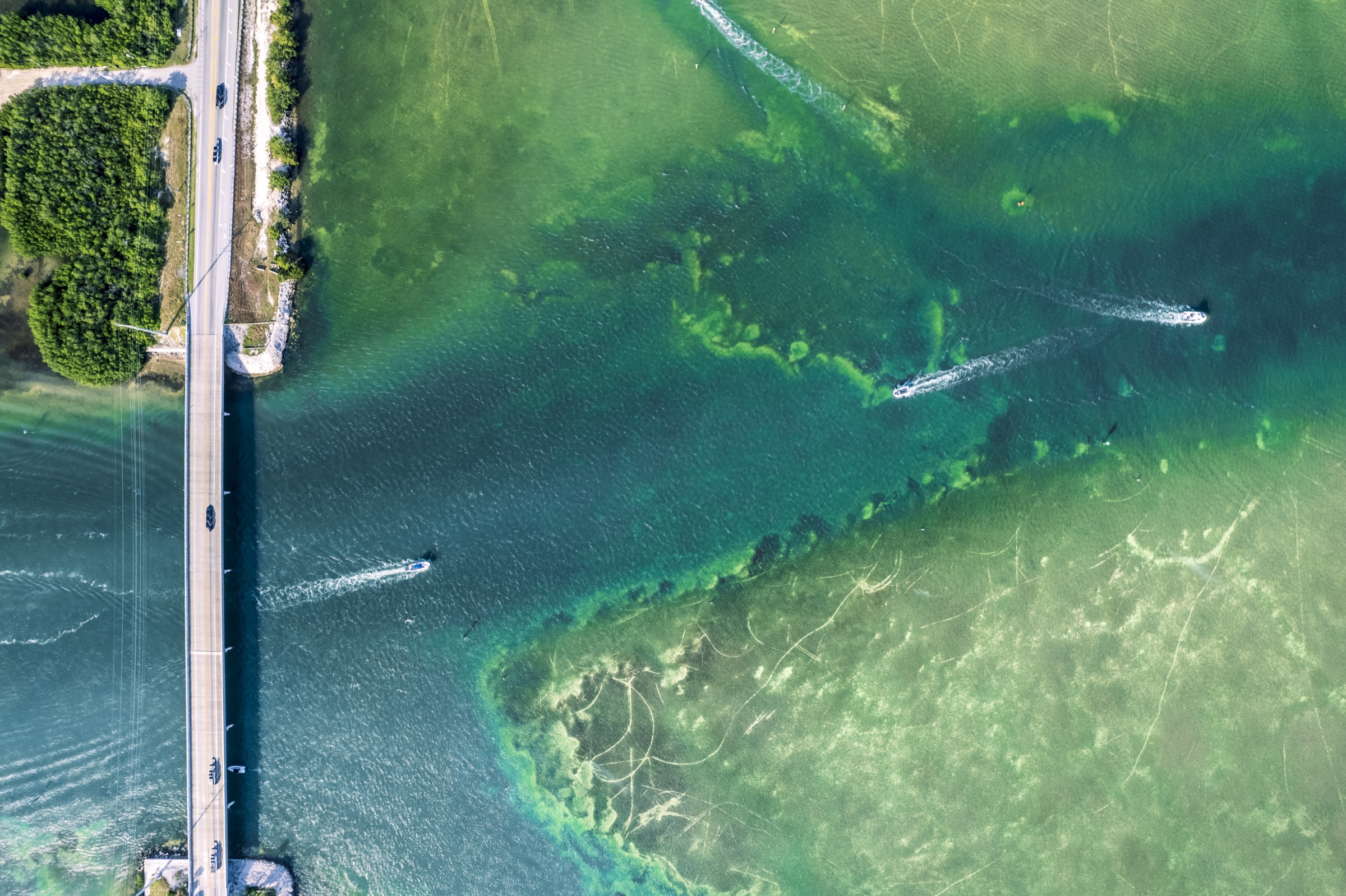 Aerial view of a Florida Keys bridge with boats crossing turquoise water