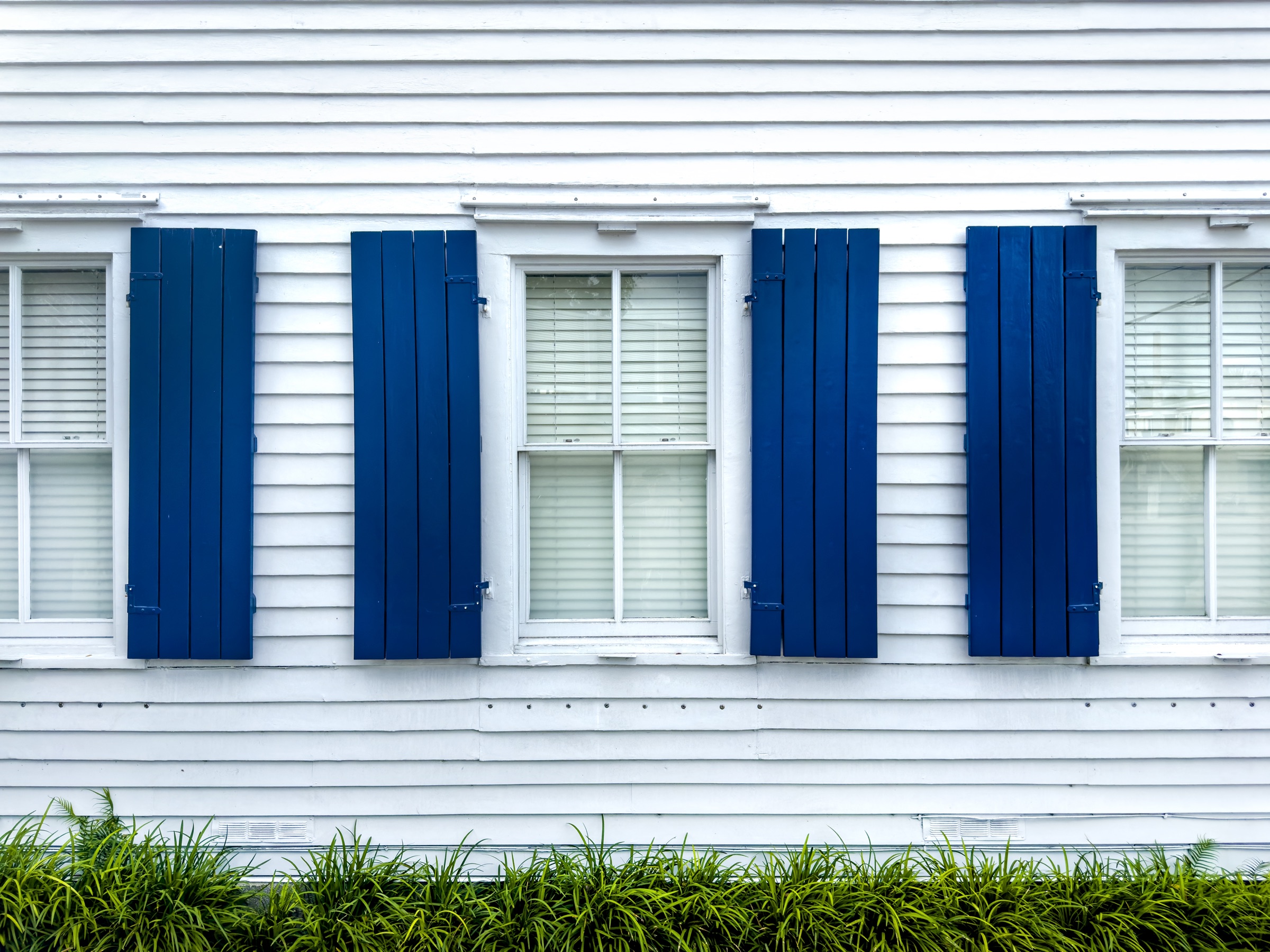 White clapboard Keys home with deep blue shutters